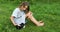 A little girl play with Black Guinea pig sitting outdoors in summer