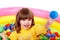 Little girl play in group colourful ball.