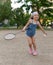 A little girl playing badminton in a yard of an apartment buiding