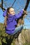 Little girl playing: climbing a tree