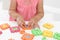 Little girl playing with colorful puzzles at white table, closeup.