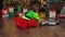 Little girl playing with colorful train toy in room decorated for Christmas with Christmas tree