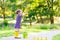 Little girl playing in forest and wearing boots