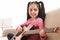 Little girl playing guitar. Learning music notes