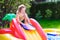 Little girl playing in inflatable garden swimming pool