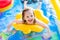 Little girl playing in inflatable garden swimming pool