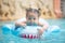 Little girl playing inflatable ring in swimming pool