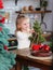 Little girl playing in kitchen with Christmas tree and New Years decor