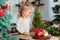 Little girl playing in kitchen with Christmas tree and New Years decor