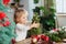 Little girl playing in kitchen with Christmas tree and New Years decor