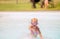 Little girl playing and laughing in a swimming pool