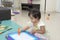 Little girl playing with magnetic drawing board on the floor