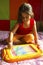 Little girl playing with magnetic drawing board, Pune, Maharashtra, India