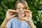 Little girl playing with a magnifying glass in her backyard make faces