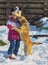 Little girl playing with a mongrel dog in the snow