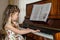 Little girl is playing the piano. A beautiful child is at a music lesson. Baby learns to play the piano