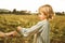 Little girl playing with plants in the field