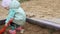 Little girl playing with a shovel in the sandbox