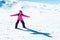 Little girl playing snowboard trainer on snow