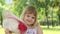 Little girl playing with a straw hat, taking it off her face and smiling; slow motion