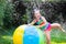 Little girl playing with toy ball garden sprinkler