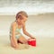 Little girl playing with toys sand set on the beach