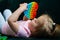 Little girl playing with trendy pop it fidget, sensory rainbow toy push pop, washable and reusable stress relief toy