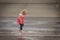 Little Girl Playing in Water Flowing Through the Gutter After Rain Storm