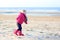 Little girl playing on winter beach