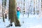 Little girl playing in winter forest