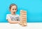 Little girl playing with wooden jenga game