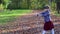 Little girl plays as archer in sunny autumn park