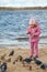 Little girl plays beach in autumn day