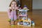 Little girl plays with a children`s constructor at home. Little girl playing with lots of colorful plastic blocks constructor and