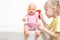 A little girl plays with a doll examines her ears. The concept of pediatric otolaryngology in medicine, treatment of otitis media