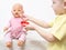 A little girl plays with a doll and treats her with pills. Pediatric medicine concept and treatment with pharmaceuticals