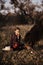 Little girl plays with horse in forest.