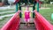 Little girl plays at playground. Small girl on climbing frame. Girl on monkey bars