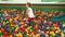 Little girl plays in the pool with spheres