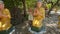 Little Girl Plays at Sitting Buddha Statues in Temple Park