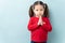 Little girl pleading with her hands in a studio