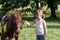 Little girl and pony horse pet on field