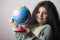 Little girl portrait holding a globe in hand and spin it