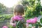 Little girl portrait smelling peony flower