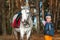 Little girl portrait, stands next to a white pony close-up on the background of nature. Jockey, epodrome, horseback riding