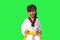 Little girl is practicing Taekwondo isolated on green background.