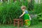 Little girl prepares Chinese tea in the yard of house.