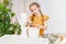 The little girl prepares dough or cream in a submersible mixer.