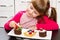 Little girl preparing cake with fruit