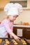 Little girl preparing cookies on kitchen